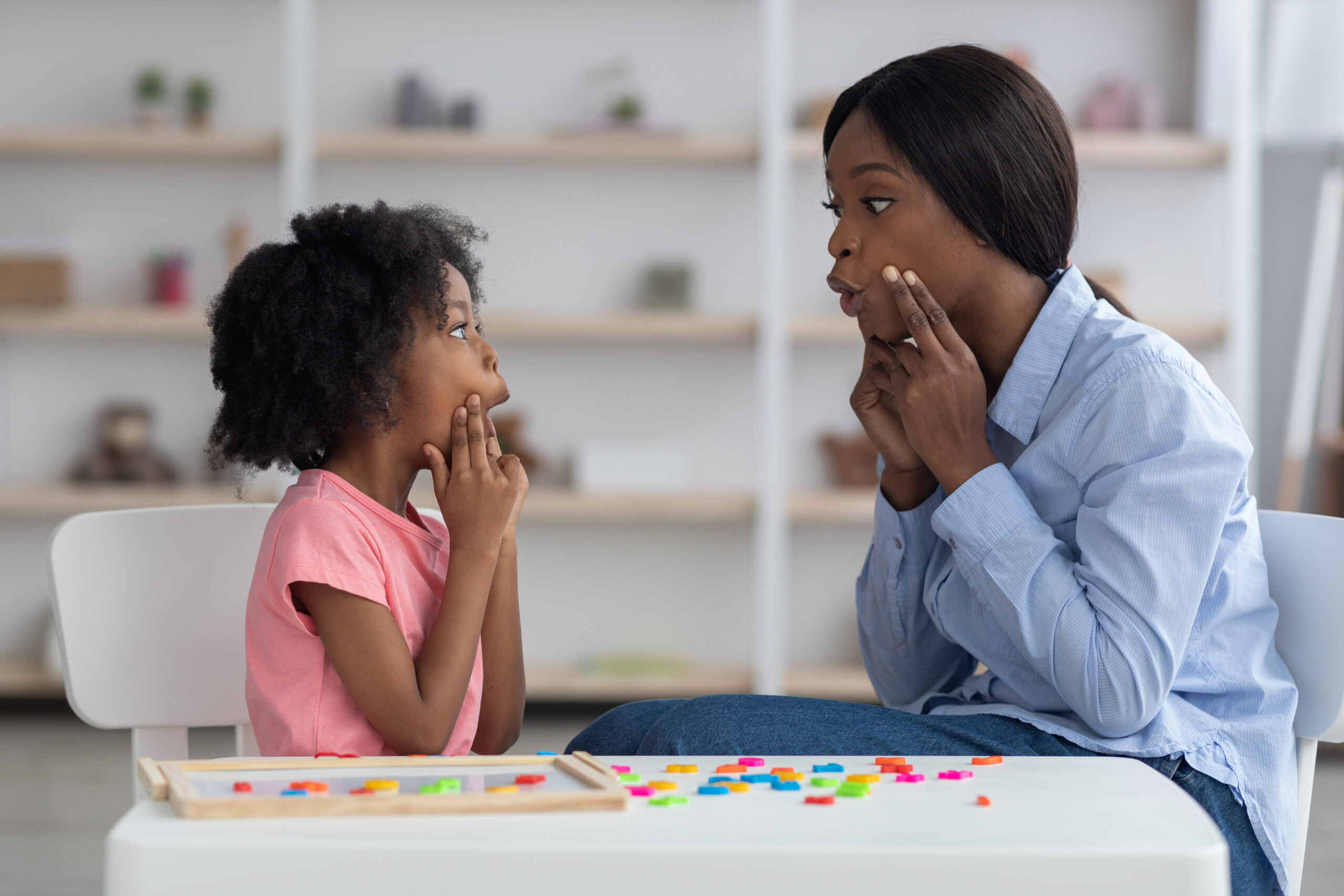 speech language pathologist having lesson with little girl