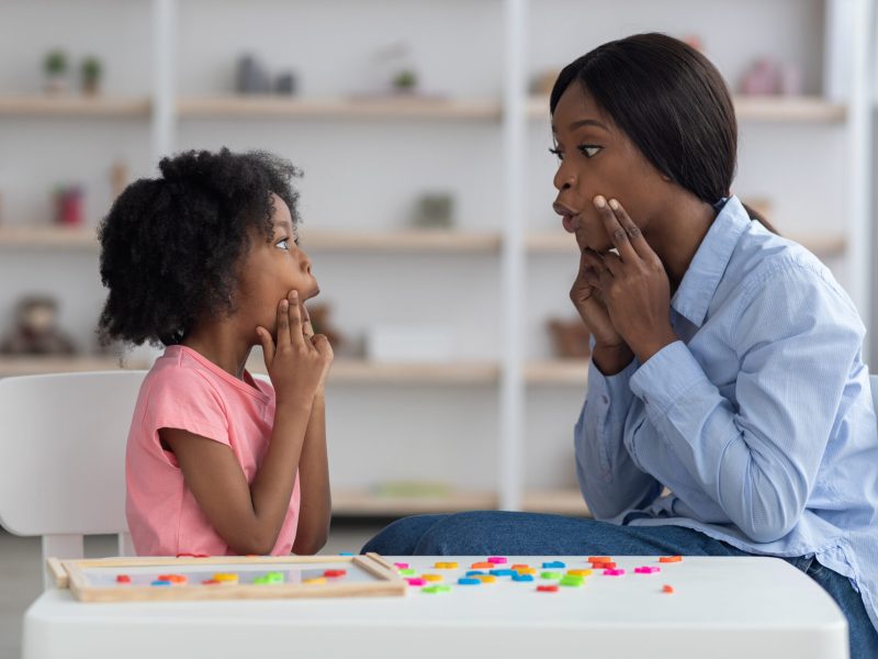 speech language pathologist having lesson with little girl